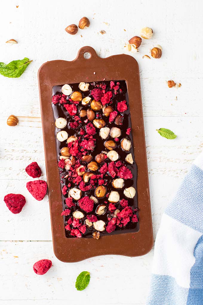 Chocolate in a mold with freeze dried raspberries and hazelnuts.