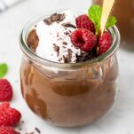 A glass jar with a rich and creamy chocolate avocado pudding.
