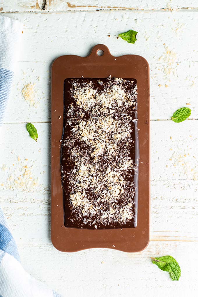 Chocolate poured into a chocolate bar mold and coated with toasted coconut.