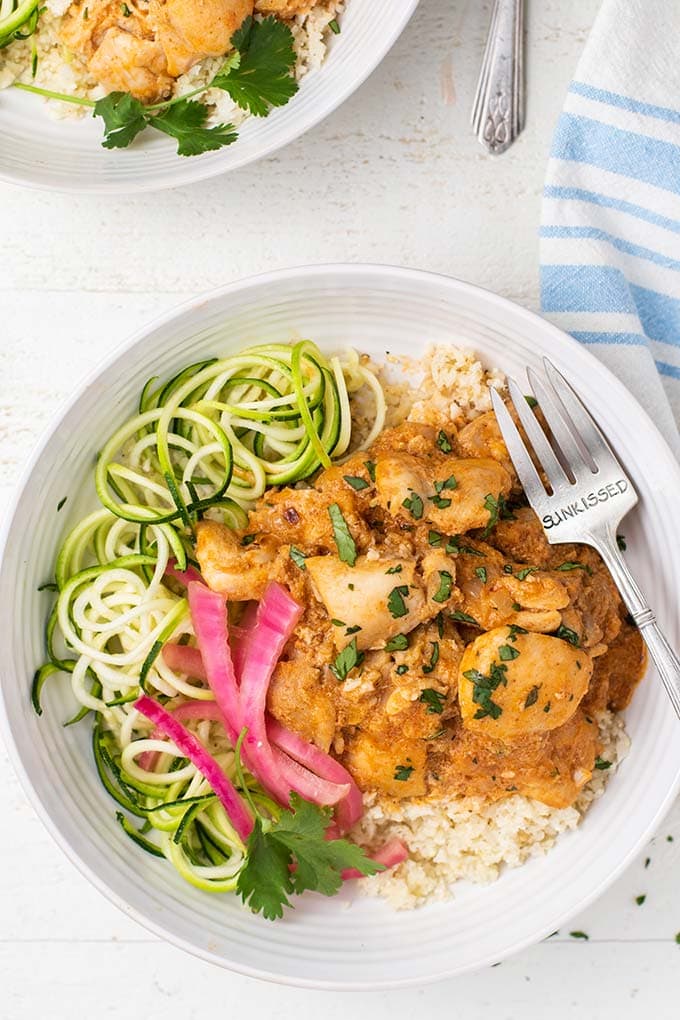 A keto butter chicken served on top of cauliflower rice and zucchini noodles.