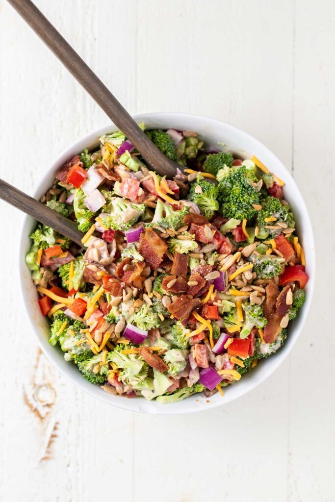 A bowl of keto broccoli salad shown tossed in a white serving bowll.