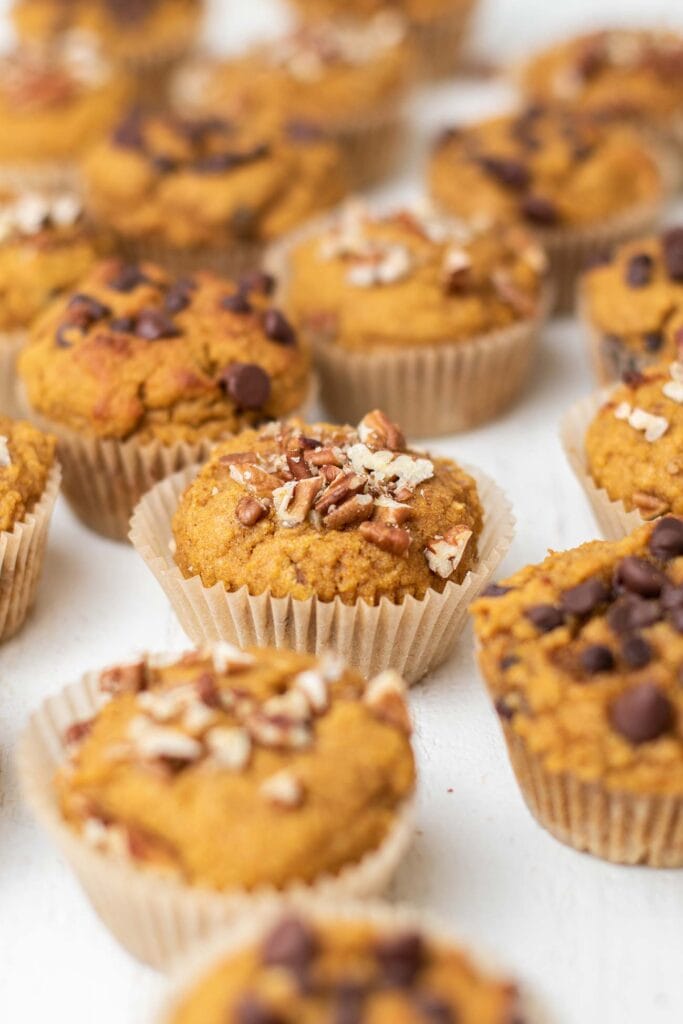 Lots of keto pumpkin muffins shown with different topping options.