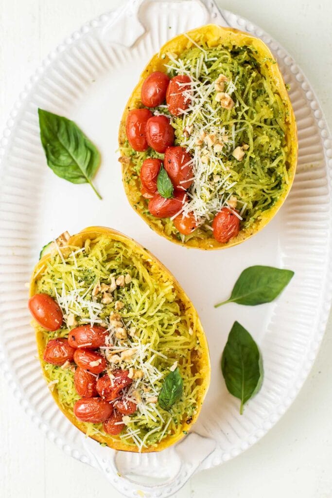 A large white platter with two spaghetti squash halves prepared.