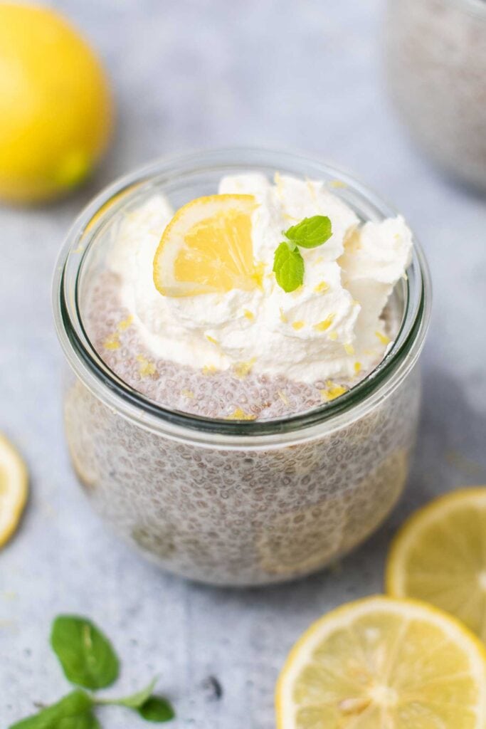 A small jar filled with lemon chia seed pudding topped with whipped cream.