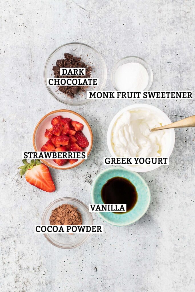 The ingredients needed to make a keto greek yogurt with chocolate and strawberries.