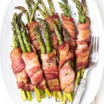A plate of Air Fryer Bacon Wrapped Asparagus shown served on a white platter.