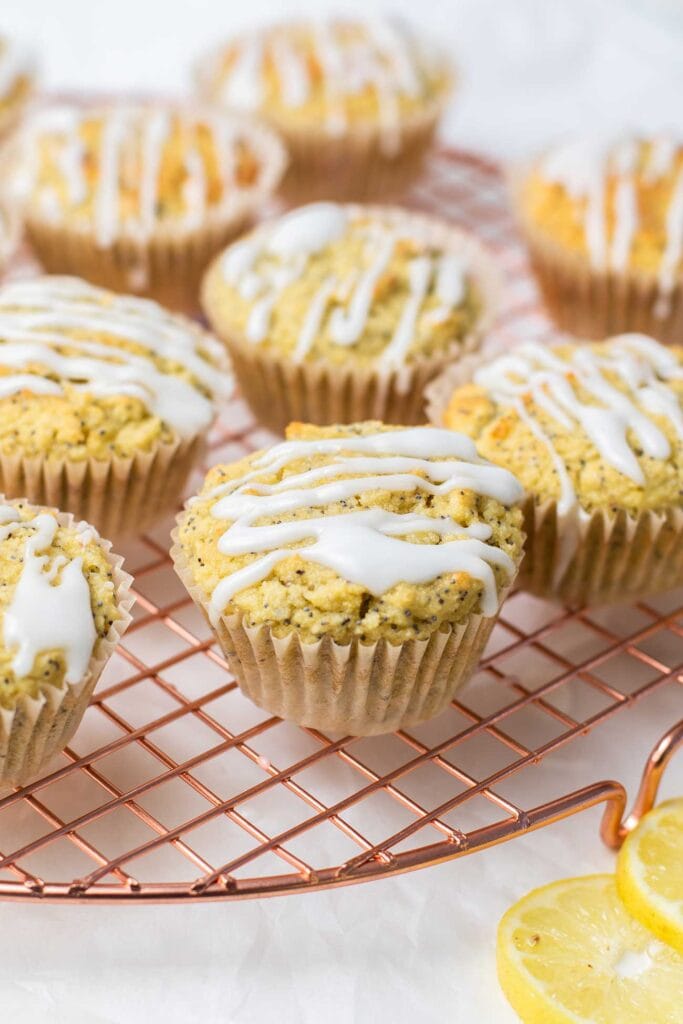 Muffins on a cooling rack shown drizzled with a lemon glaze.