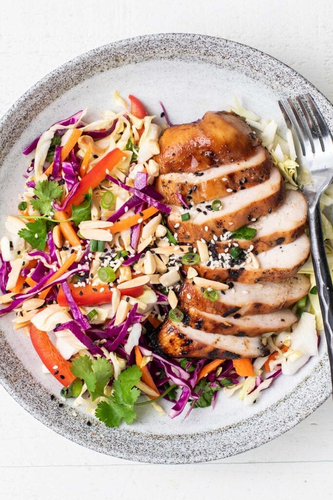 An Asian Sesame Salad topped with tender ginger marinated chicken.