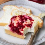 Fluffy slices of zero carb bread spread with butter and raspberry jam.