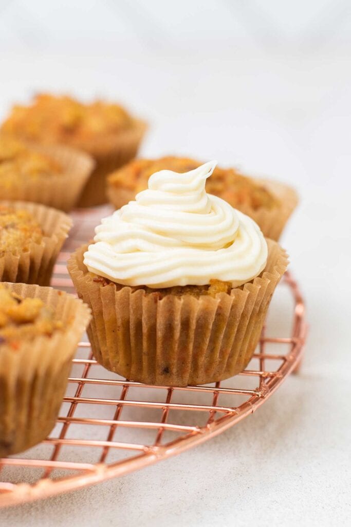 a carrot cake cupcake topped with cream cheese frosting.