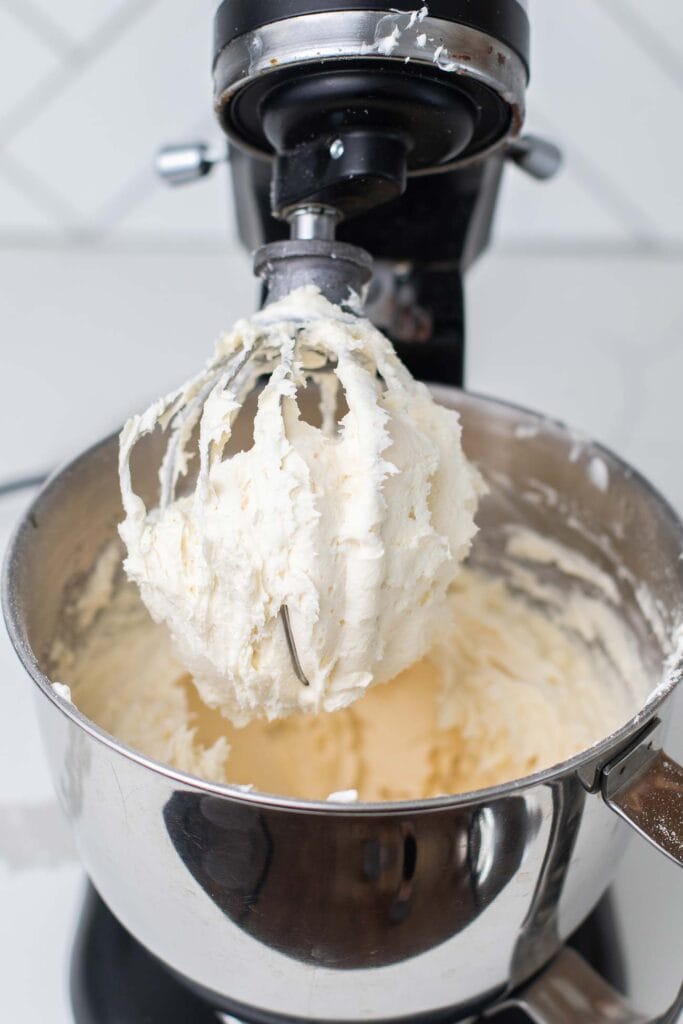 Perfectly whipped cream cheese frosting on a mixer whisk attachment.