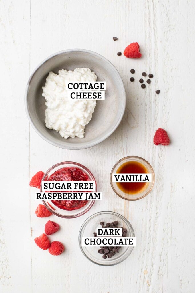 The ingredients needed for a chocolate raspberry cottage cheese bowl.