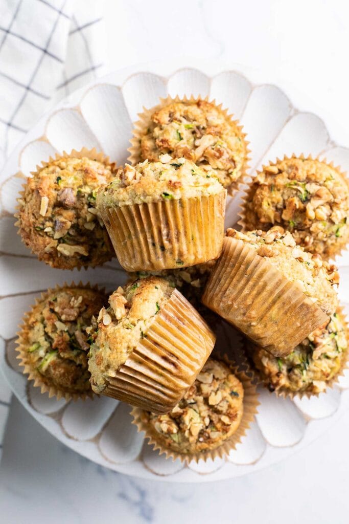 Keto Zucchini Muffins stacked on a cake stand.