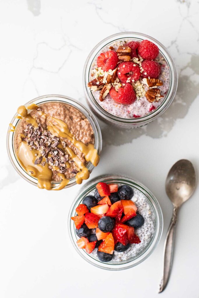 3 jars of chia pudding shown with a variety of toppings.