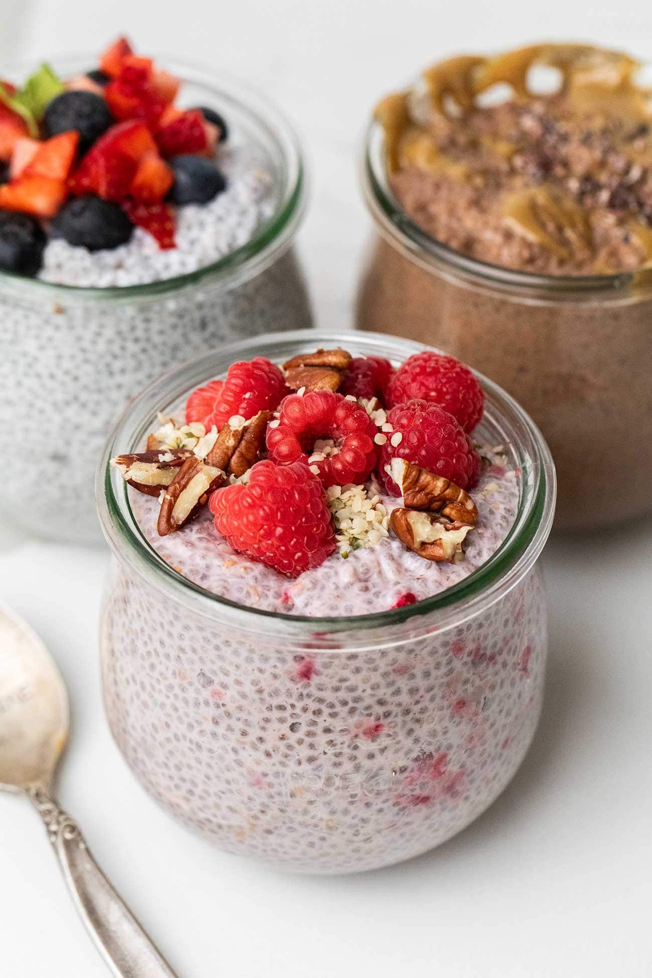 3 jars of protein chia pudding shown with toppings.